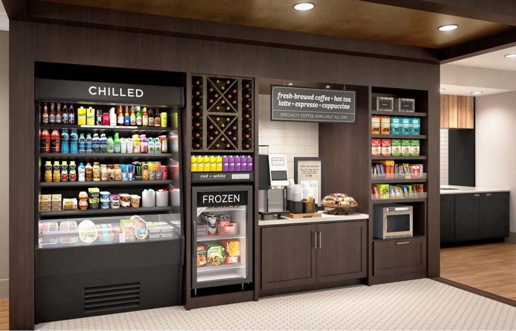 Dark wood hotel market millwork with chilled drink case, frozen unit, wine rack, coffee station and snack shelves